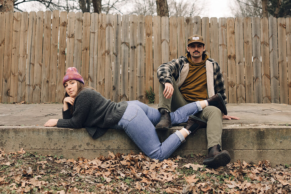 Edgy couple lounge near one another for engagement photos