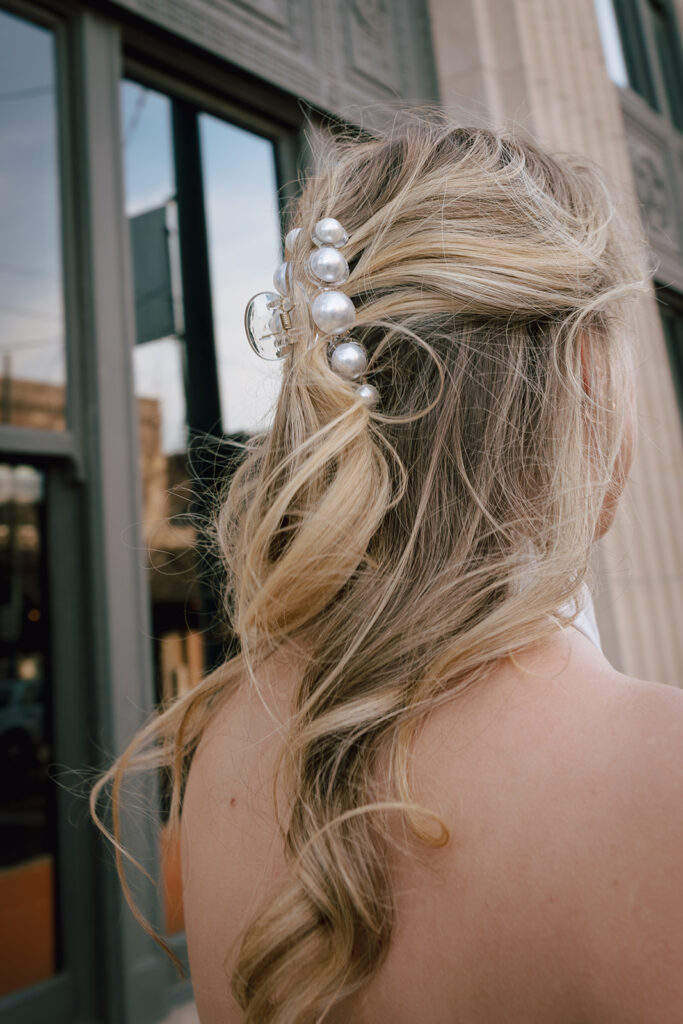 detail image of a pearl hair clip in the hair of a blonde woman for engagement photos
