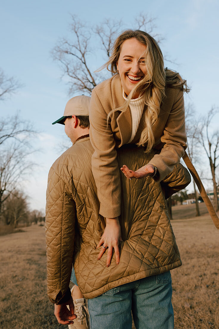 engaged woman being picked up by her fiancé in the winter for engagement photos